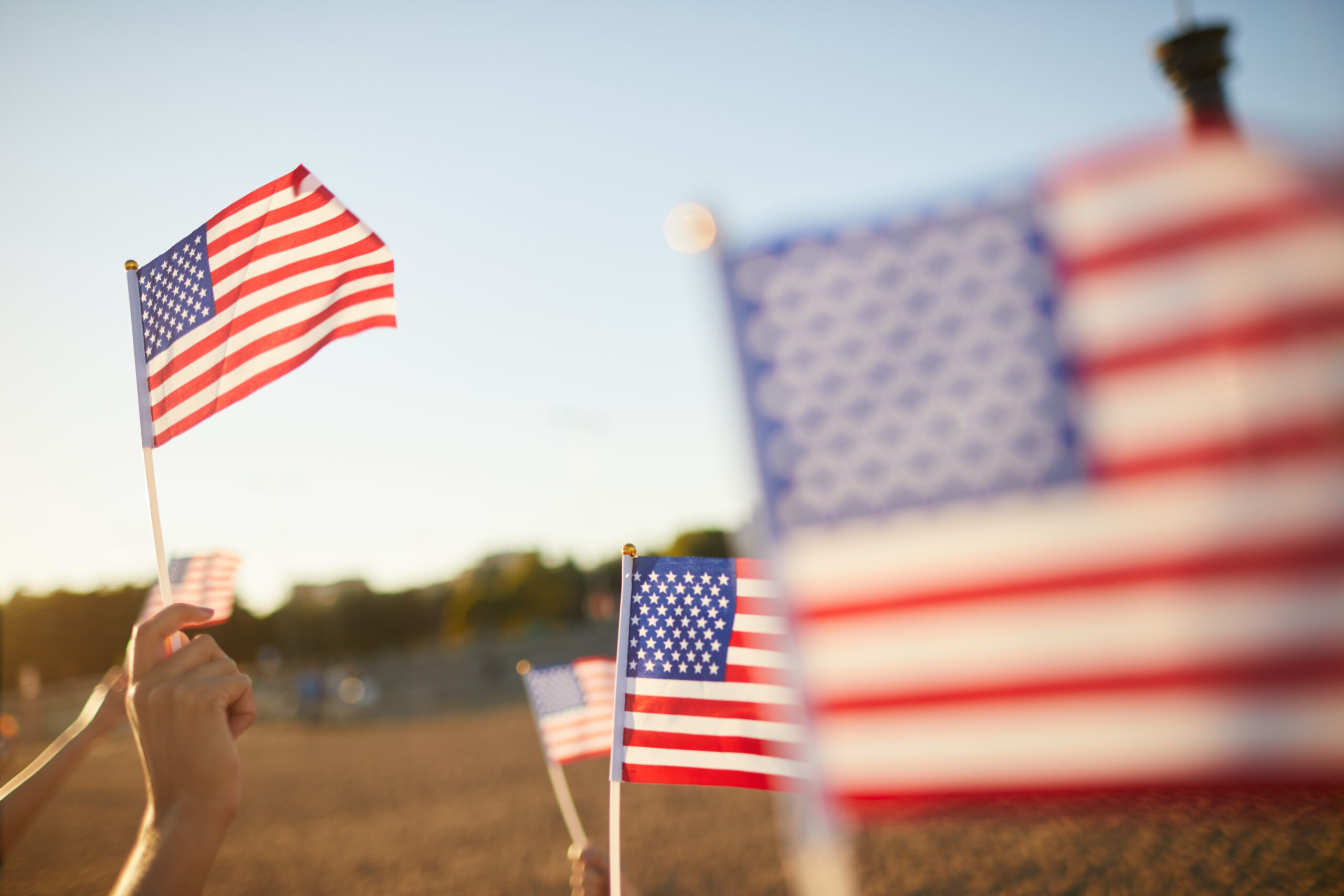 waving flags at sunset for the fourth of july